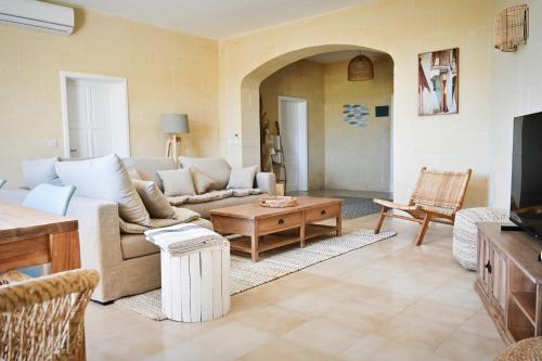 a living room with a couch and a table at Ogygia Suites Gozo in Għarb