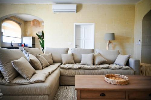 a living room with a couch and a coffee table at Ogygia Suites Gozo in Għarb