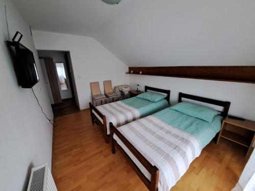 2 camas individuais num quarto com televisão em Privatni smještaj Tolić em Ladimirevci