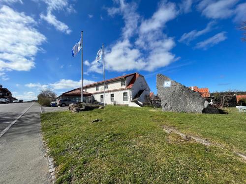 dos banderas volando delante de un edificio en Danhostel Sandvig en Sandvig