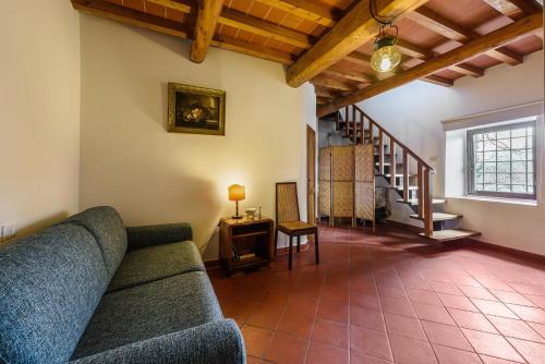 a living room with a couch and a staircase at Tenuta Poggio ai Mandorli in Greve in Chianti