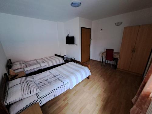 a bedroom with two beds and a television in it at Privatni smještaj Tolić in Ladimirevci