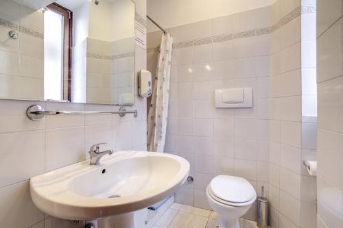 a white bathroom with a sink and a toilet at Hotel Primavera in Rome