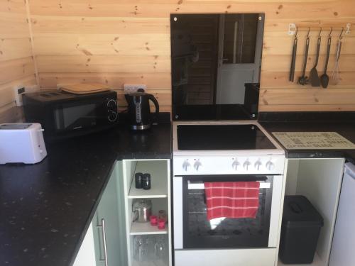 a small kitchen with a stove and a microwave at Beacon House Bunks in Bridlington