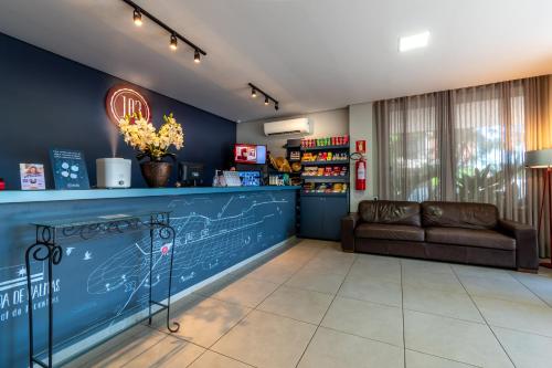 - une salle d'attente avec un canapé et un comptoir dans l'établissement 103 Hotel & Flats, à Palmas