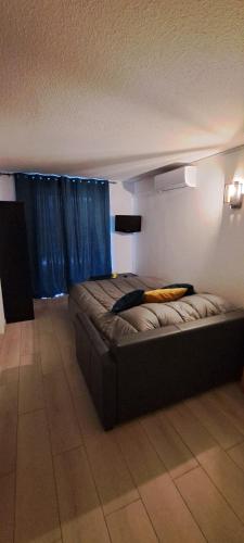 Cette chambre comprend un grand lit et des rideaux bleus. dans l'établissement Le Cap d'Agde, très proche village naturiste, 2 mn à pied, un coin de détente dans la pinède, au Cap d'Agde