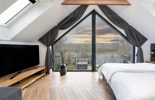 a bedroom with a large bed and a large window at odNova - Holiday home with SPA in Bobolin