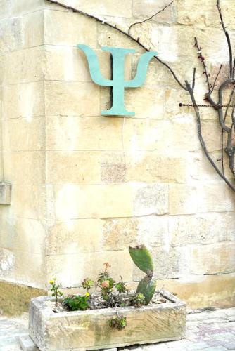 a sign on the side of a stone wall with a planter at Ogygia Suites Gozo in Għarb
