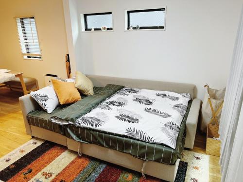 a couch with a blanket on it in a living room at 成田羽田空港直行 skytree 上野 asakusa 銀座直行 駅から徒歩8分新築戸建 駐車場付いてない in Tokyo