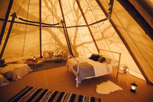um quarto numa tenda com uma cama e uma mesa em GreenWood Family Park em Y Felinheli