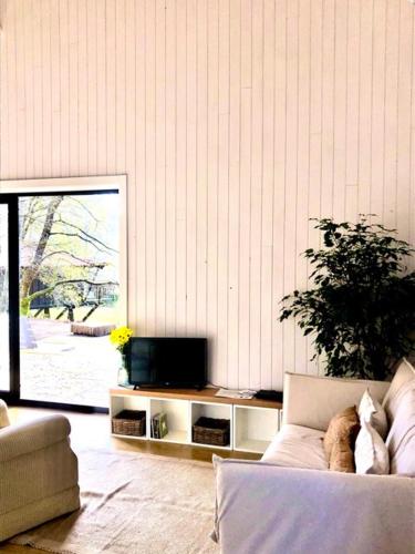 a living room with a couch and a tv at Quinta Lamosa Agroturismo in Arcos de Valdevez