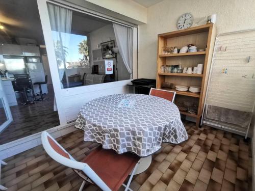 une salle à manger avec une table et des chaises et une fenêtre dans l'établissement 5031 Ambassade du Soleil 513, au Cap d'Agde