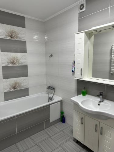 a bathroom with a tub and a sink and a mirror at ВІП квартира в новобудові в центрі міста in Rivne