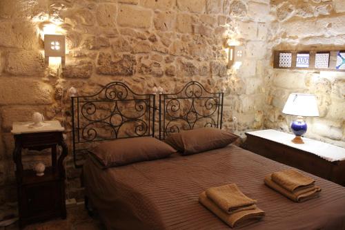een slaapkamer met een bed met twee handdoeken erop bij Malta & Tufo in Altamura