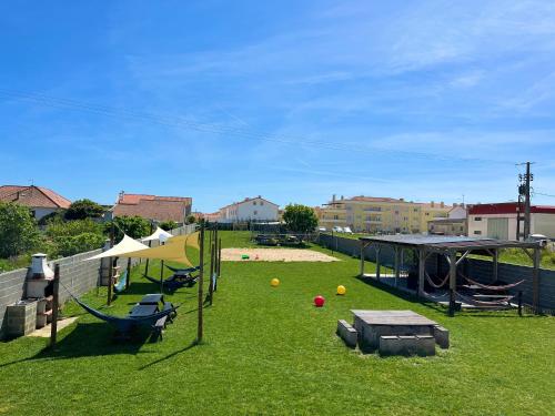a backyard with a playground with a swing set at W.H.House in Atouguia da Baleia