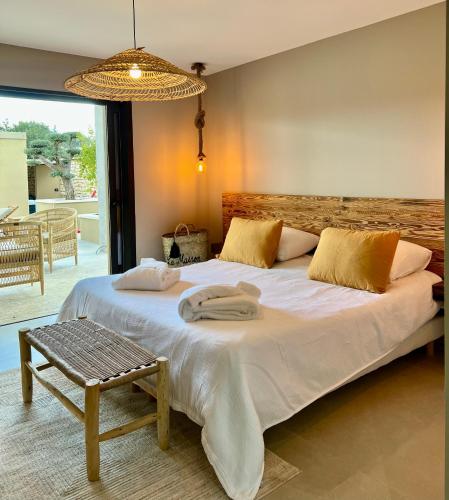 - une chambre avec un grand lit blanc et un banc dans l'établissement La Maison d'Ambrine - La Villa Ibiza, à Chamaret