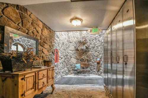 y baño con pared de piedra y ducha. en Chateaux Dumont 2704, en Keystone