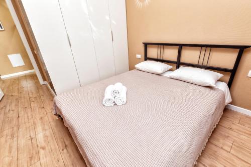 1 dormitorio con 1 cama con 2 toallas en Абрикосовое парфе en Astaná
