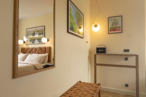 a bedroom with a mirror on the wall and a bed at Hotel Mayfair in Copenhagen
