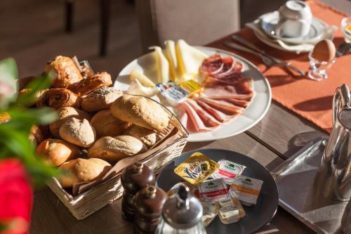 a table topped with two plates of bread and pastries at Hotel Les Mouettes in Wenduine