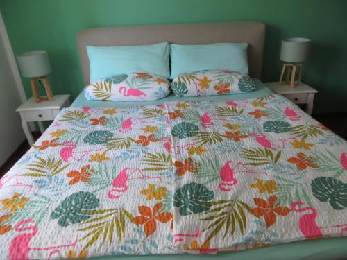 a bed with a colorful comforter and two pillows at Zur Gartenlaube in Bullay