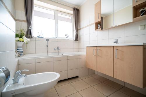 a bathroom with a sink and a bath tub and a sink at App Kapitänsdeck 415 am Müritzufer in Rechlin