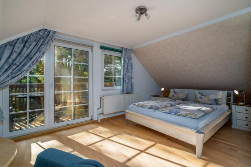 a bedroom with a bed and two large windows at Ferienwohnung Seebusch in Schwarz
