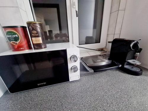 a microwave sitting on the floor next to a kitchen at Hostel Monument in Bucharest
