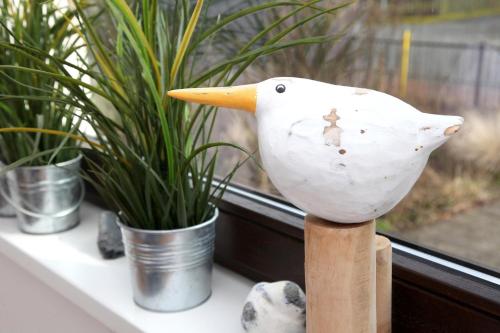 a wooden bird statue on a table next to plants at Ferienwohnung Utkiek an der Müritz in Rechlin