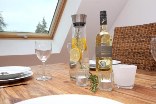 a bottle of wine sitting on a wooden table with glasses at Ferienwohnung Utkiek an der Müritz in Rechlin