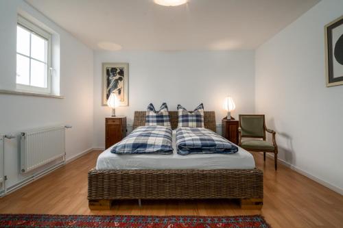 1 dormitorio con 1 cama con almohadas azules y blancas en Ferienwohnung 1 im Landhaus am Wildpark Boek, en Boek