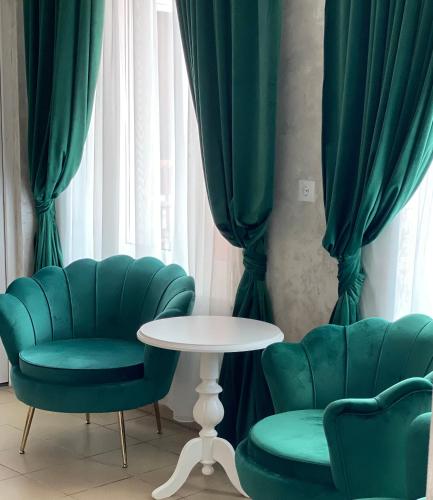 a room with two chairs and a table and curtains at Pensiunea Korona in Miercurea-Ciuc