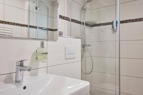 a bathroom with a sink and a shower at Hotel Isha in Frankfurt/Main