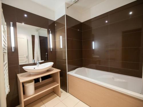W łazience znajduje się umywalka, wanna i umywalka. w obiekcie Studio confortable avec terrasse, piscine et sauna à Jausiers - 4 pers, 27 m² - FR-1-165B-51 w mieście Jausiers