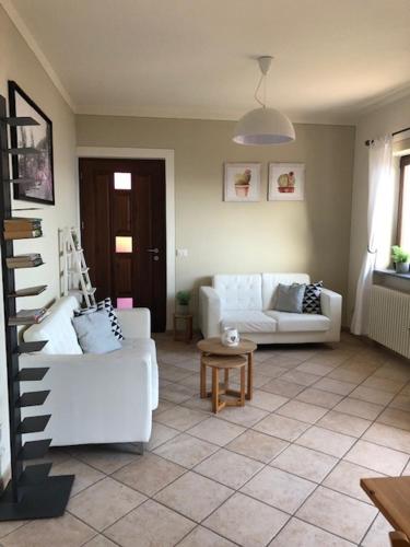 a living room with two white couches and a table at Appartamento Torilla in Trarego