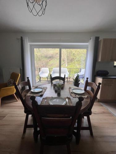 a dining room with a table and chairs and a room with a window at Pina's Appartment in Namur
