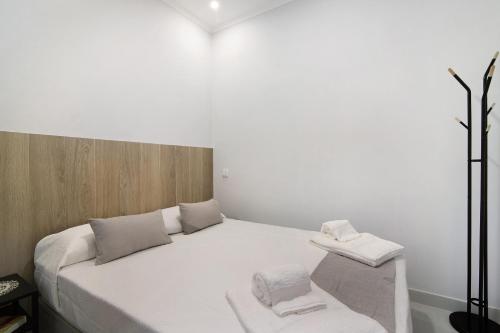 een slaapkamer met een wit bed en 2 handdoeken bij Casa Anzol in Fuzeta