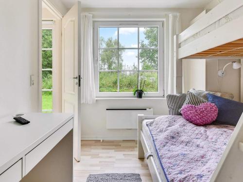 a small bedroom with a bed and a window at Holiday home Aabenraa LXIX in Aabenraa