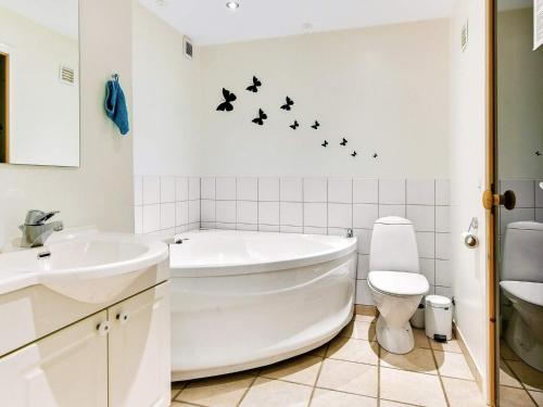 ein Badezimmer mit einer Badewanne, einem WC und einem Waschbecken in der Unterkunft Holiday home Aabenraa LXIX in Aabenraa