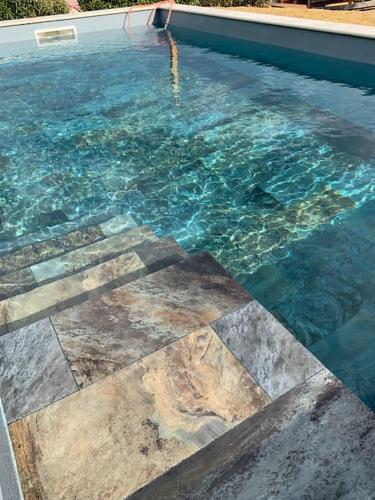 d'une piscine d'eau bleue et de carrelage. dans l'établissement Villa sud de la France avec piscine privée, à Les Fumades-Les Bains