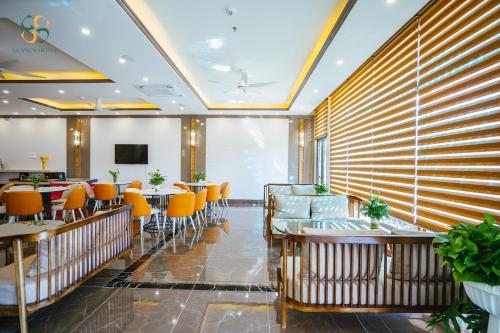下龍灣的住宿－Ha Long Seasun Hotel，餐厅设有桌椅和大窗户。