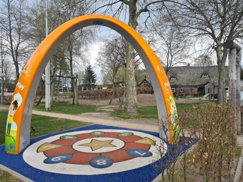 an arch in a park with a painting on the ground at Chalet Panorama near Efteling - with garden and swimmingpool Europarcs in Kaatsheuvel