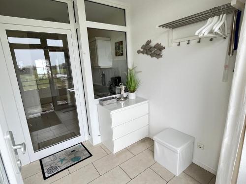 a white bathroom with a sink and a toilet at Ferienwohnung Andreas Seeblick in Großenbrode