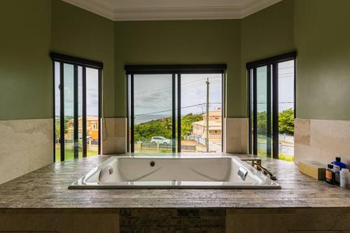 a large bath tub in a room with windows at Villa Belle in Egmont