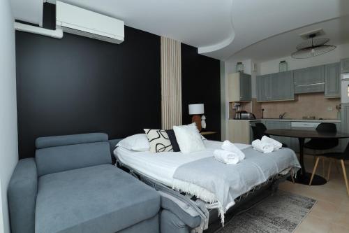 a bedroom with a bed and a couch at "Le beach", plein centre, climatisé in Menton