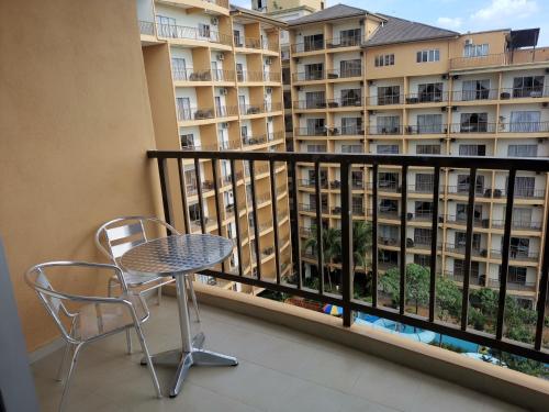 a balcony with a table and chairs and a large building at Gold Coast Morib Rerost By Sweetime in Kampong Tanjong Pechah