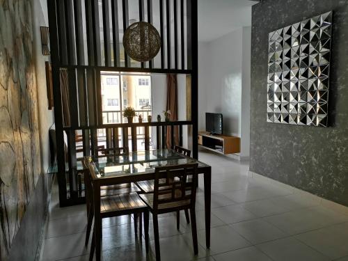 a dining room with a glass table and chairs at Gold Coast Morib Rerost By Sweetime in Kampong Tanjong Pechah