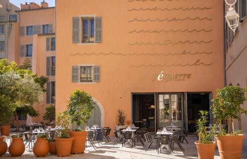 a restaurant with tables and chairs in front of a building at L'Eautel Toulon Centre Port in Toulon