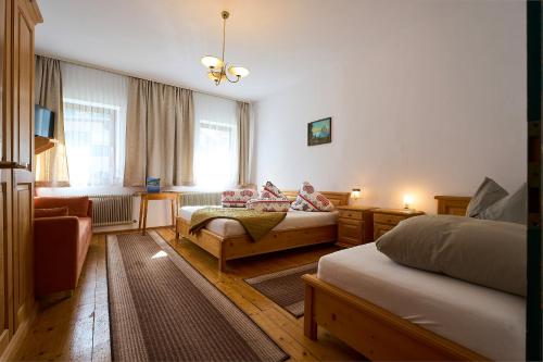 Habitación de hotel con 2 camas y sofá en Gasthof Lamm, en Sankt Jodok am Brenner