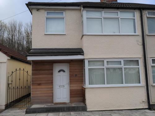 una casa con una puerta y ventanas blancas en Liverpool, en Liverpool